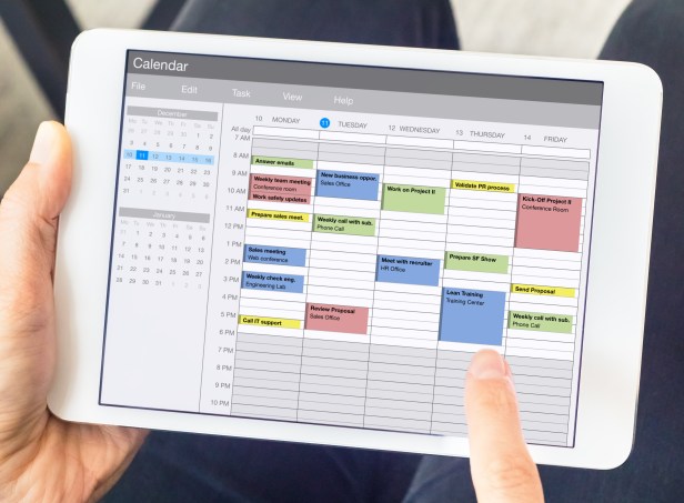 Calendar app on tablet computer with planning of the week with appointments, events, tasks, and meeting. Hands holding device, time management concept, organization of working hours planner, schedule
